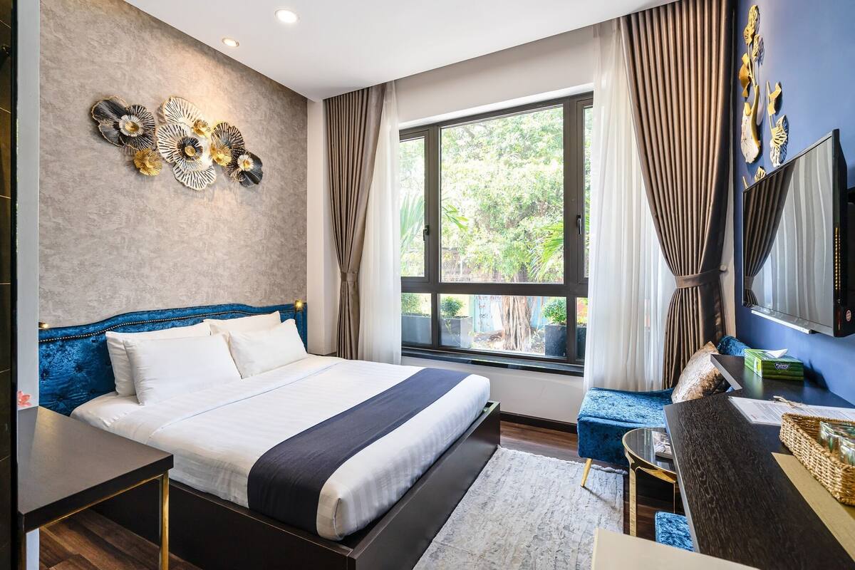 Une chambre d’hôtel moderne équipée d’un grand lit, d’un bureau, d’une chaise et d’un téléviseur.
