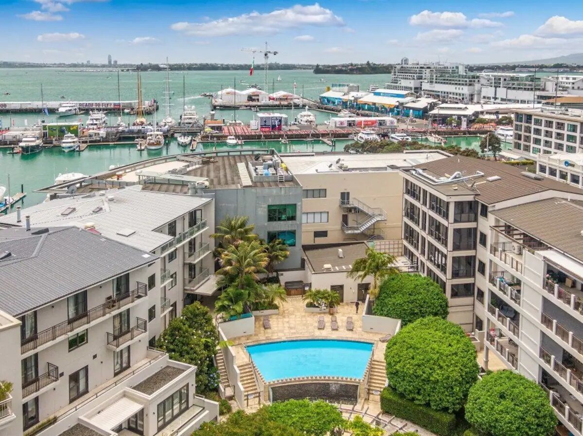 Ein Yachthafen mit Booten, einem Schwimmbad und modernen Gebäuden.