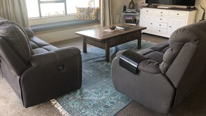 A living room with two leather sofas, a coffee table, a TV, and a cabinet.