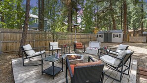 An outdoor patio with wicker furniture, a fire pit, and a small shed. - *Home Gym* A/C* Fenced-in Yard (Flagstaff)