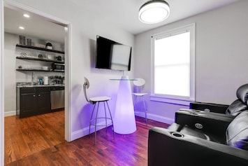 Inviting living room area with ceiling fan, flat screen Roku TV, lighted seating area for two, as well as two electric reclining chairs for the ultimate comfortable entertainment experience.