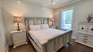 A bedroom with a large bed, two nightstands, a dresser, and a ceiling fan. - Private Beach Access|Golf Cart|Pool|Spa|Bikes (Rosemary Beach)