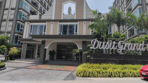 A modern building with a prominent entrance, large windows, and a sign that reads "Duisit Grand".