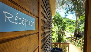 A wooden reception desk with a sign reading "Réception." - Hôtel Hamaha Beach (Mamoudzou)