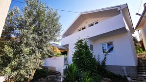 A modern two-story building with a white facade, a small balcony, and a stone staircase leading to the entrance. - Holiday House O'Live - private house with a garden few steps from the sea (Marina)