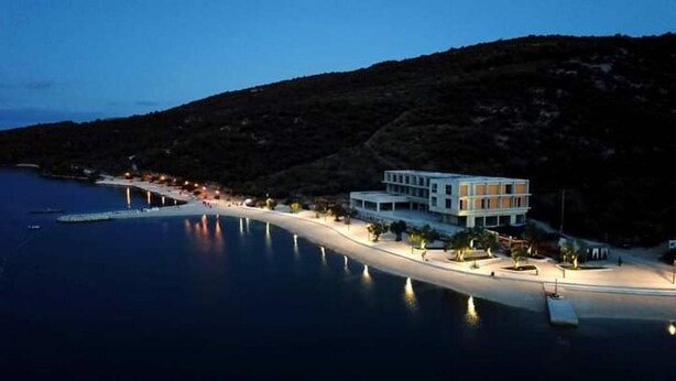 A coastal hotel with a modern design, featuring a large building with multiple floors and a flat roof, situated on a sandy beach with a calm sea in the background. - Holiday House O'Live - private house with a garden few steps from the sea (Marina)