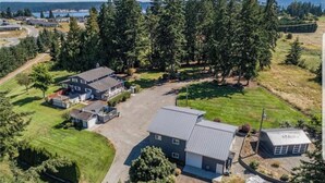 An aerial view of a residential property with multiple buildings, a driveway, and surrounding greenery. - Secluded in the Heart of Sequim (Sequim)