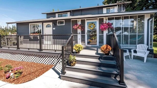 A modern two-story house with a covered porch, a small deck, and a front door with a wreath. - Secluded in the Heart of Sequim (Sequim)