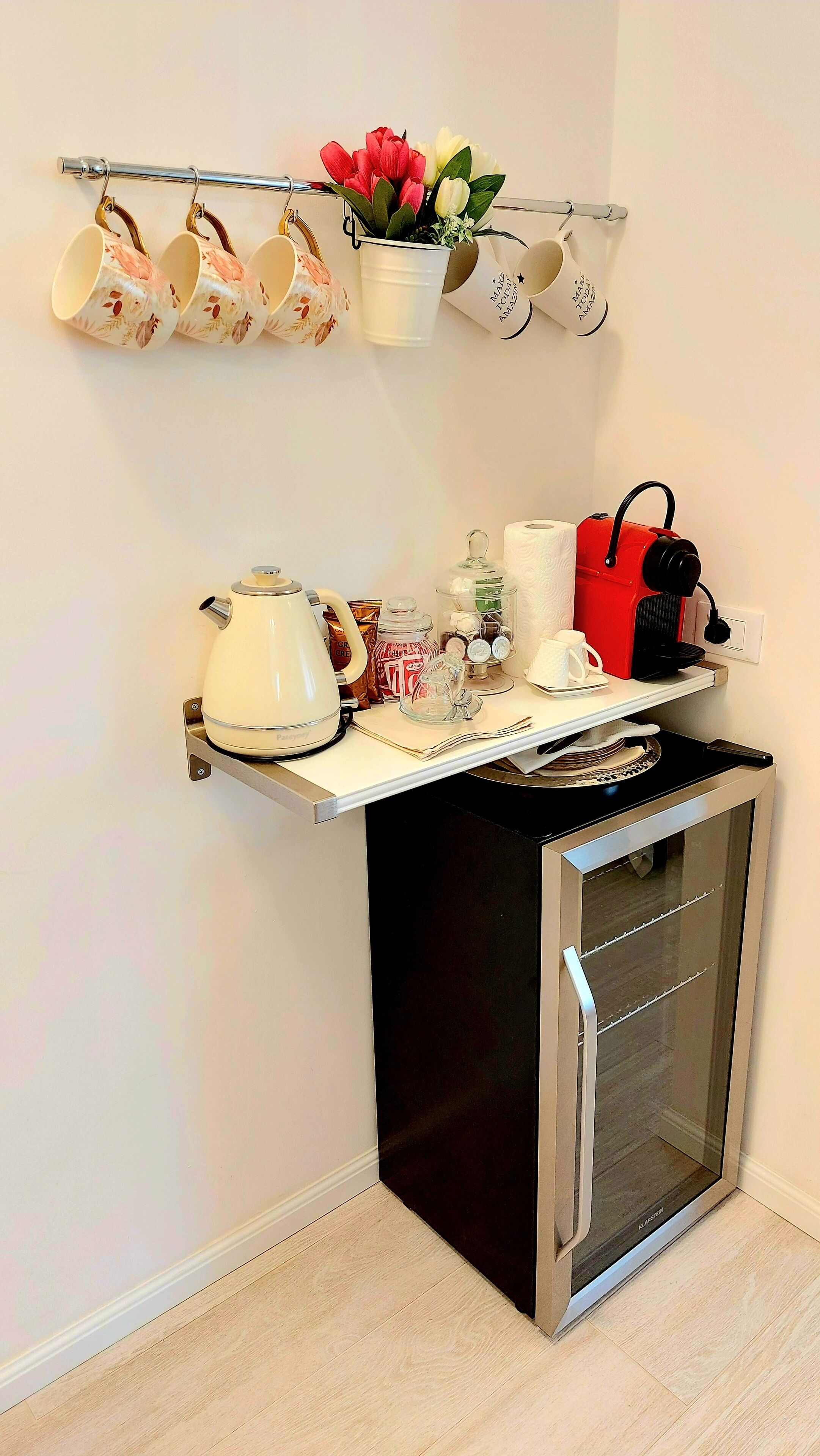 A compact kitchenette with a built-in oven, a coffee maker, and a small countertop.