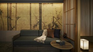 A modern living room with a sofa, a small round table with a lamp, and a wall with a bamboo pattern. - Minn Gion Sanjo (Kyoto)