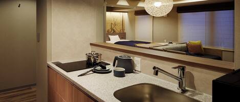 A modern bathroom with a large sink, a mirror, and a hanging light fixture.