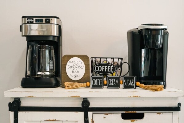 Two coffee makers on a white shelf with a coffee bar sign and three labeled blocks for coffee, cream, and sugar. - Another Day In Paradise: Nights of Lights (St. Augustine Vilano Beach)