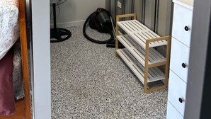 A compact room with a bunk bed, a small desk, a chair, a vacuum cleaner, a fan, and a storage cabinet. - Clermont Guest House (Clermont)