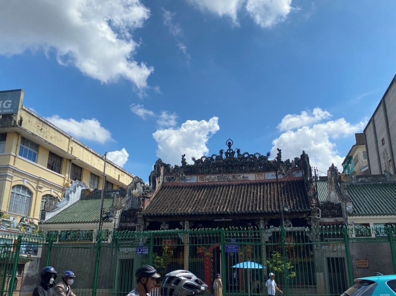 A traditional building with ornate architecture, a gated entrance, and a clear blue sky.