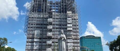 Una estatua frente a un edificio en construcción con andamios.