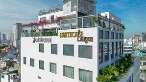 A multi-story building with balconies, a rooftop terrace, and a sign for 'LIGHTHOUSE DAIGON.' - CityHouse NEST LightHouse Saigon (Ho Chi Minh City)