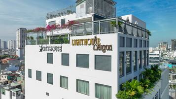 A multi-story building with balconies, a rooftop terrace, and a sign for 'LIGHTHOUSE DAIGON.'