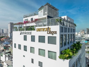 A multi-story building with balconies, a rooftop terrace, and a sign for 'LIGHTHOUSE DAIGON.' - CityHouse NEST LightHouse Saigon (Ho Chi Minh City)