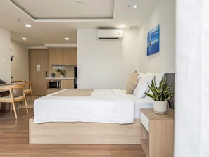 Una habitación de hotel moderna con una cama, una mesita de noche y una planta en maceta.