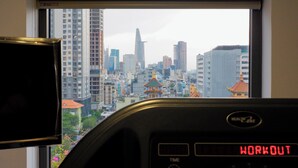 A view of a cityscape through a window, a digital clock displaying 'WORKOUT,' and a car dashboard with a speedometer. - CityHouse NEST LightHouse Saigon (Ho Chi Minh City)