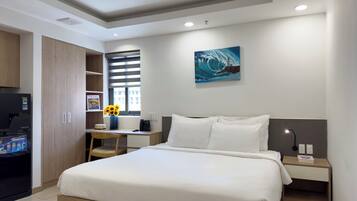 A bedroom with a bed, a desk, a chair, a TV, and a painting on the wall.