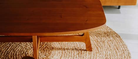 Una mesa de centro de madera con un tapete tejido debajo.