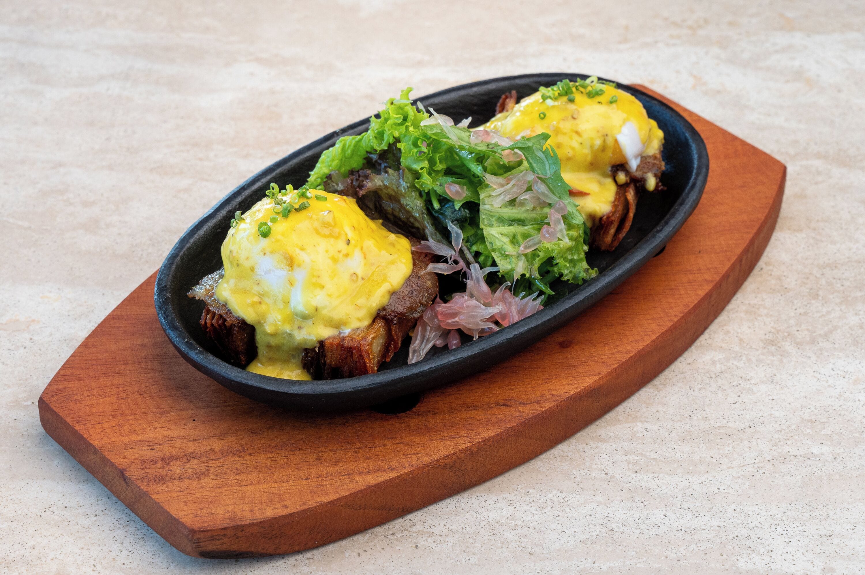 Un plato con huevos y verduras sobre una tabla de madera.