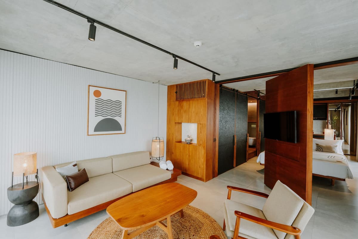 Una sala moderna con un sofá, una mesa de centro de madera y un televisor.