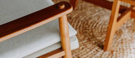 A wooden bench with a woven rug underneath.