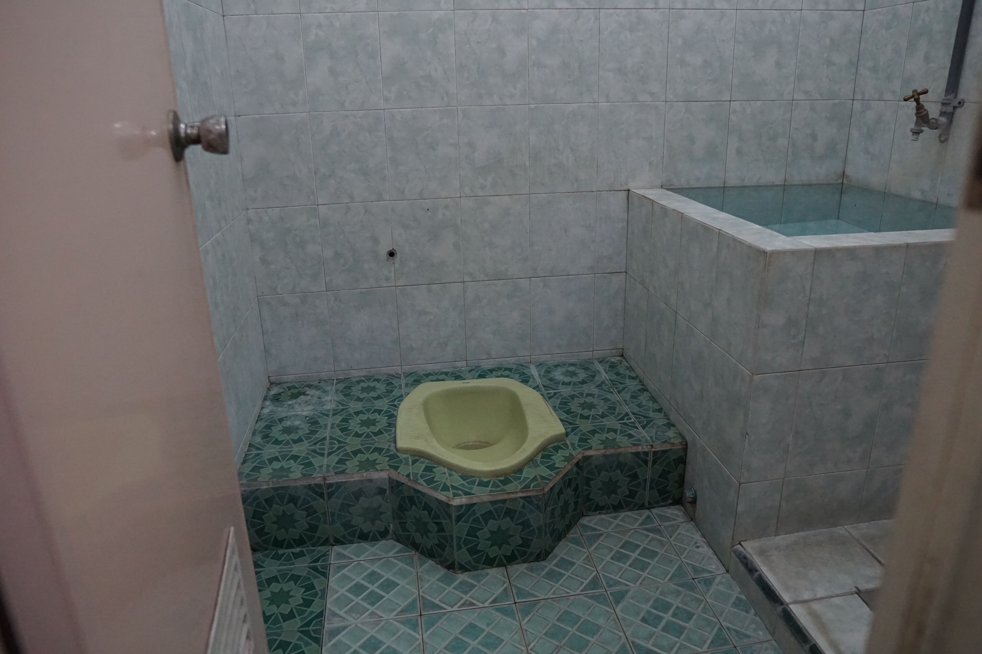 Une petite salle de bain avec des toilettes, un lavabo et une douche.