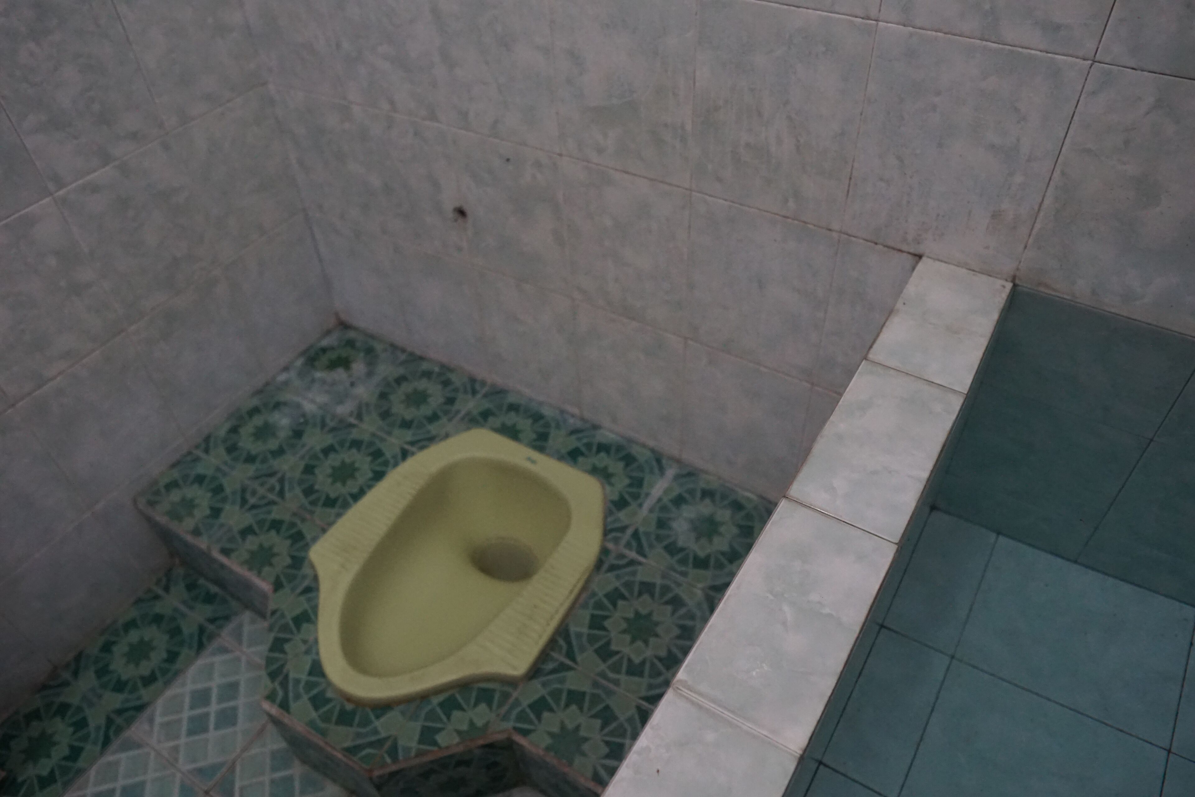 Un baño pequeño con piso de azulejos y un inodoro de pedestal.