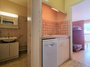 Cozinha compacta com lava-louças Bosch, pia e painel de azulejos.