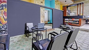 A café with a laptop on a table, chairs, and a toy car. - Capital O 92670 Borobudur Homestay (Banyuwangi)