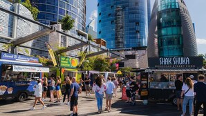 Ein lebhafter Streetfood-Markt mit Essensständen, darunter 'Sweet & Savory Crepes' und 'Shak Shuka'.