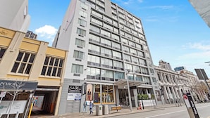 Ein mehrstöckiges Gebäude mit moderner Fassade, großen Fenstern und einem gut sichtbaren Eingang mit Glastür.