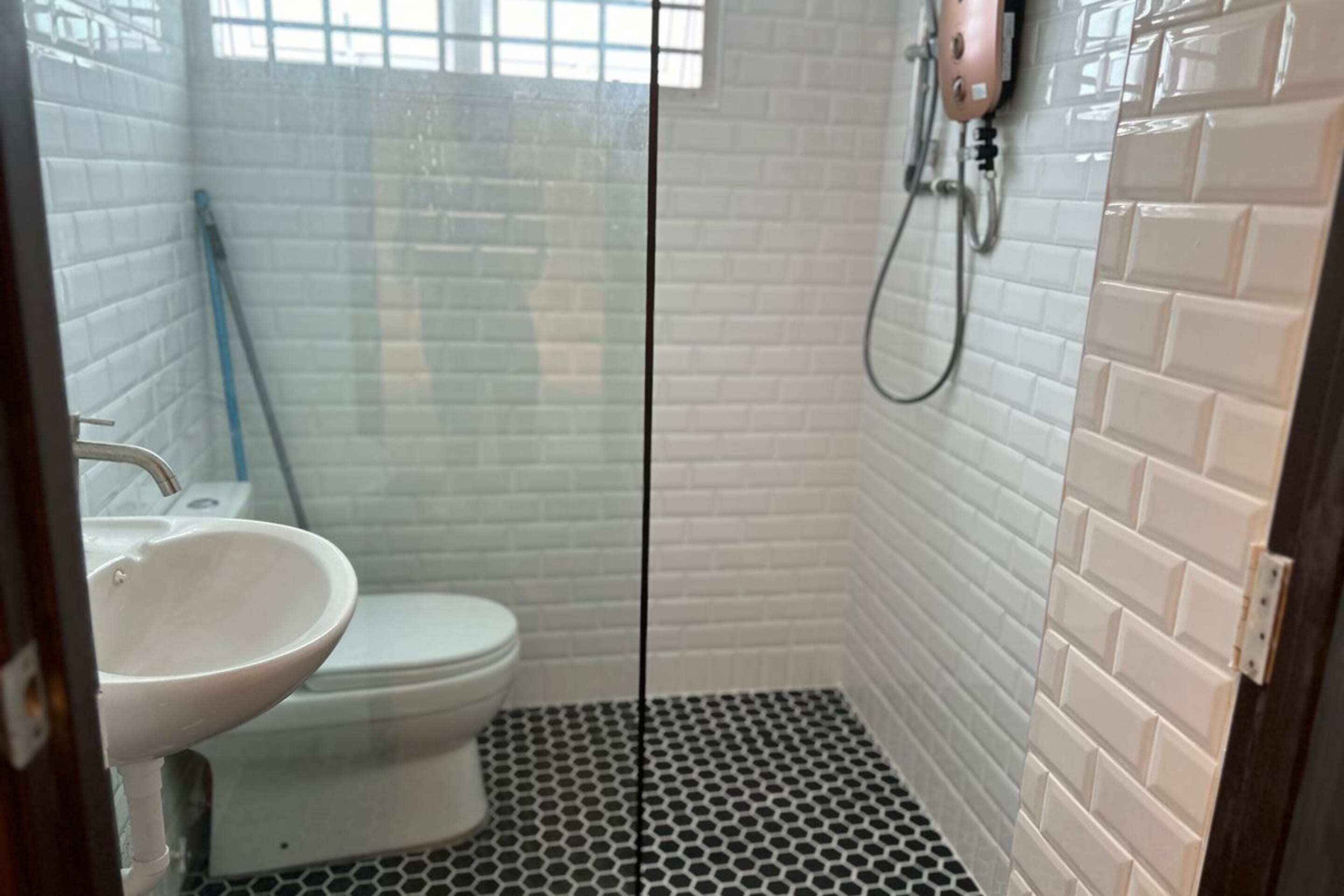 Un baño pequeño con inodoro, lavamanos y ducha.