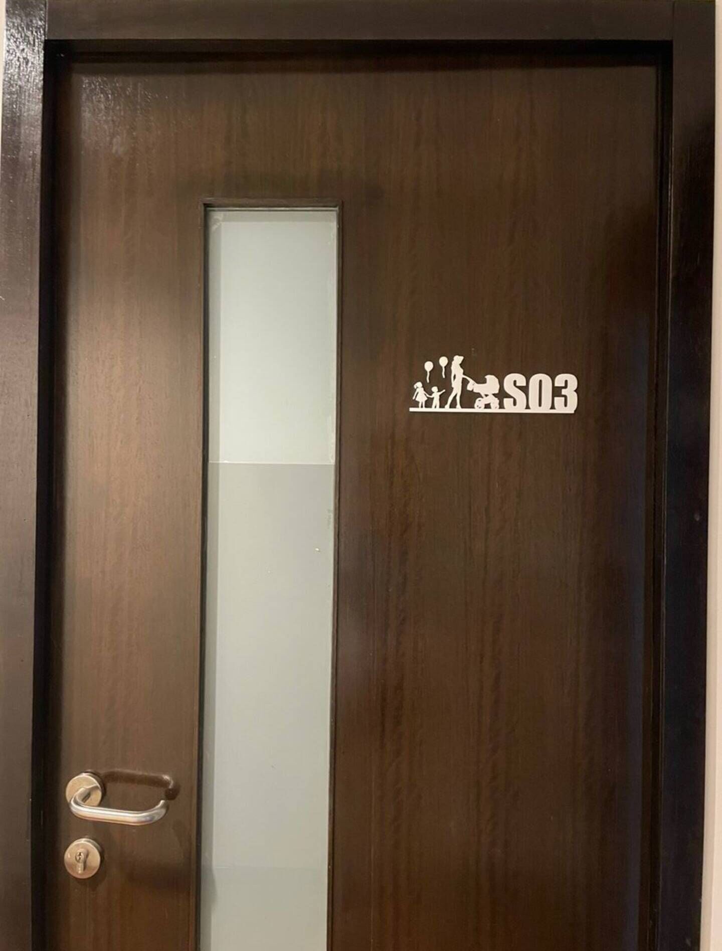 A wooden door with a frosted glass panel and a metal handle.