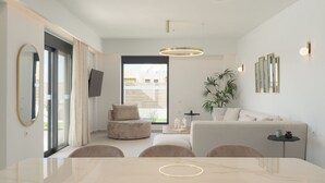 Una sala de estar moderna con un sofá, una mesa de comedor y un ventanal grande.