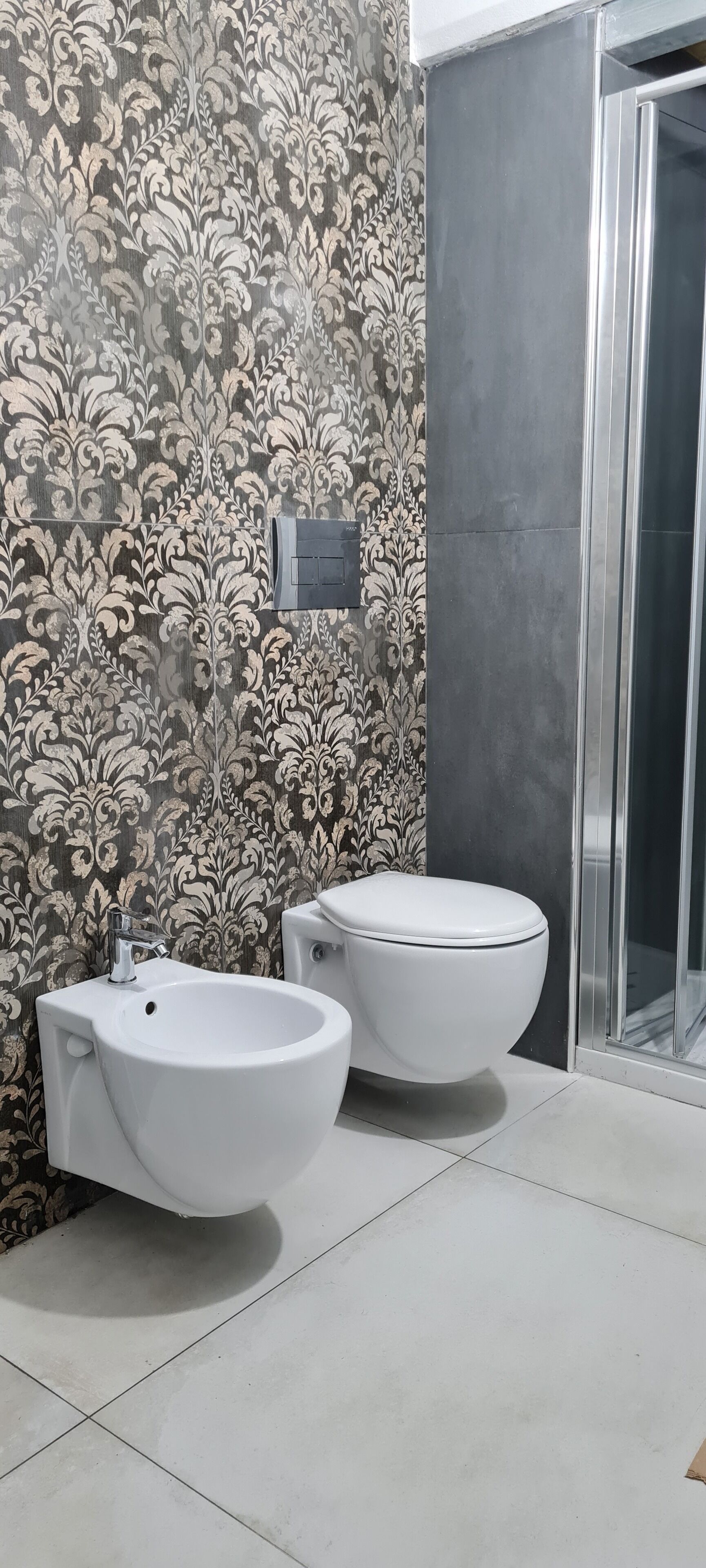 A bathroom with a bidet, a toilet, and a shower area.