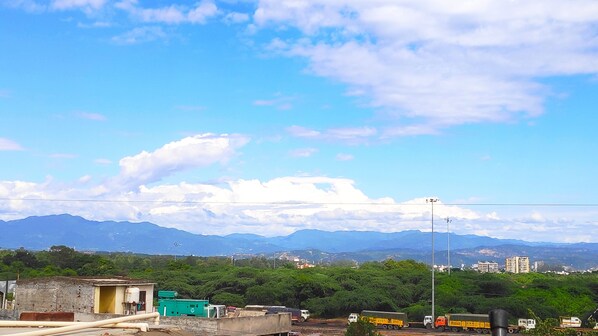 Une vue sur un paysage montagneux, avec un ciel dégagé et quelques nuages épars.
