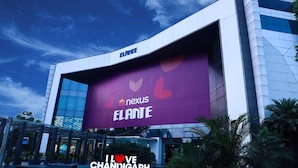 Un edificio moderno con un gran anuncio que promociona 'ELANTE' y 'nexus'.