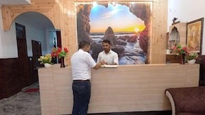 Una recepción con un cuadro de un atardecer sobre rocas.