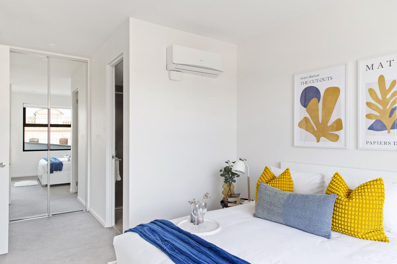 Un dormitorio moderno con cama, mesita de noche y una obra de arte en la pared.