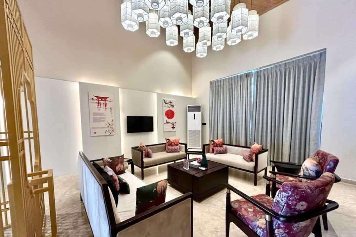 A modern living room with a sofa set, a coffee table, and a decorative light fixture.