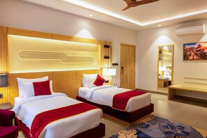 Habitación de hotel con dos camas, cabecero de madera, un espejo grande y una decoración en tonos rojo y blanco.