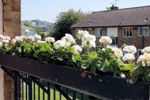 Stunning garden view of a charming brick house with lush flowering plants and a grassy lawn.