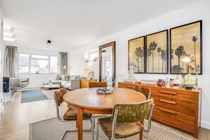 Relax in this inviting living room with a round dining table, comfortable sofa, and large window.