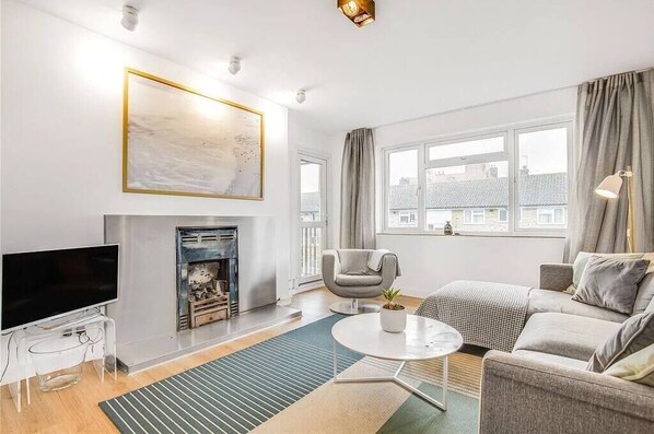 Relax in this stylish living room with a flat-screen TV, fireplace, and comfortable sofa.
