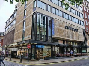 A modern building with a sign reading "CURZON" on the facade.