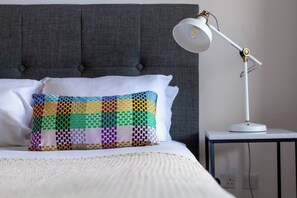 Cozy retreat with a tufted headboard bed, bedside table, and stylish lamp.